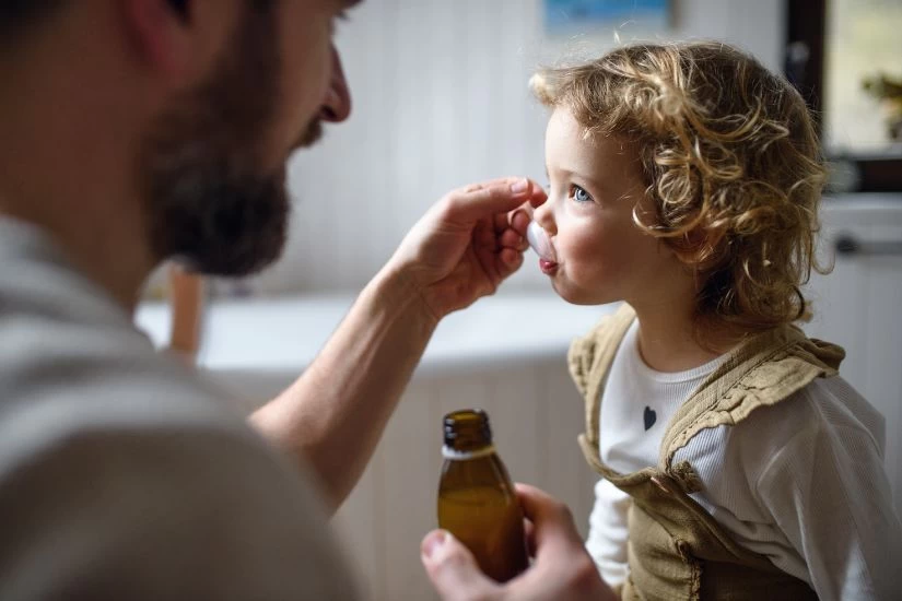 Roditelj daje detetu sirup za apetit.